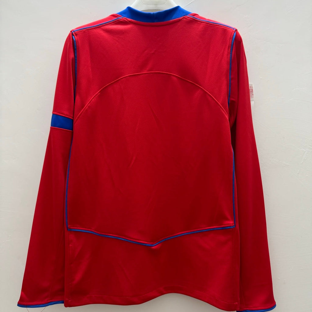 Maillot PSG troisième version à manches longues, marque Le 12-ème Maillot, en tissu bleu avec logo et détails rouges.