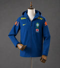 Veste coupe-vent réversible Le 12ème Maillot Brésil Blue, léger et imperméable, avec logo et design coloré visible sur l'image.