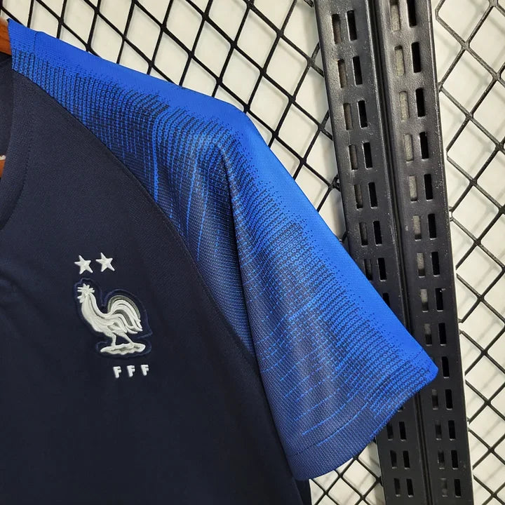 Maillot rétro de l'équipe de France 2018, marque Le 12 -ème Maillot, avec logo officiel et design vintage visible.