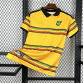 Maillot domicile 25/26 Jamaïque, marque Le 12-ème Maillot, maillot de football jaune avec logo et détails verts.