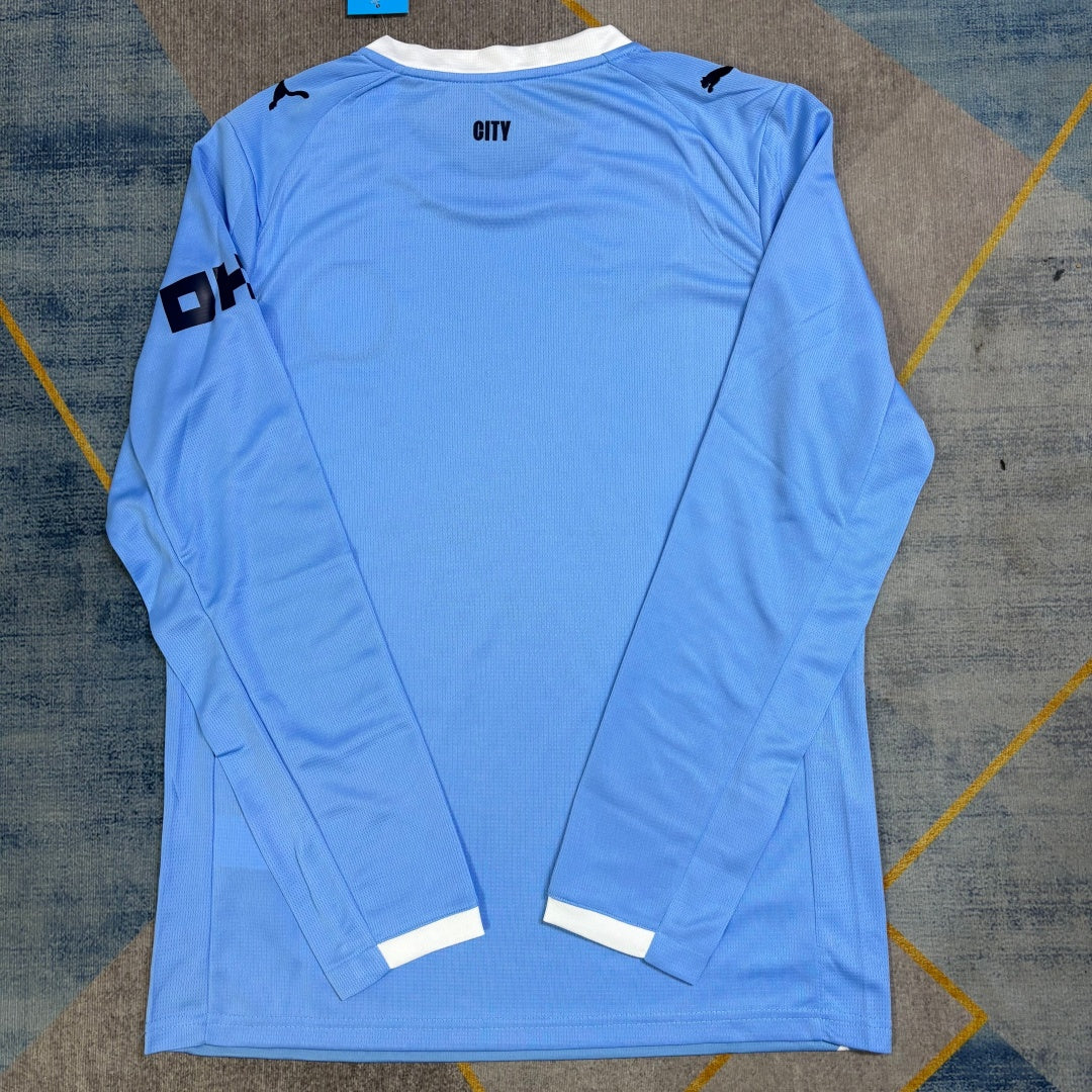 Maillot domicile Manchester City 25/26 à manches longues, marque Le 12 -ème Maillot, en bleu avec logo du club.