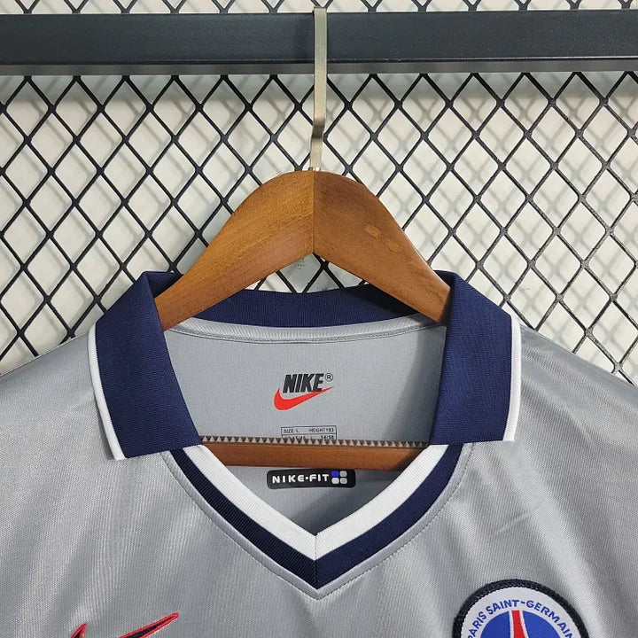 Maillot Paris Retro 2000 de Le 12 -ème Maillot, vue de face, avec design vintage et logo officiel, tissu en coton bleu et blanc.
