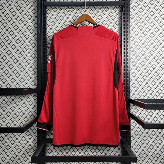 Maillot Manchester United 2023 2024 à manches longues, veste officielle Le 12 -ème Maillot, en tissu rouge avec logo sur la poitrine.