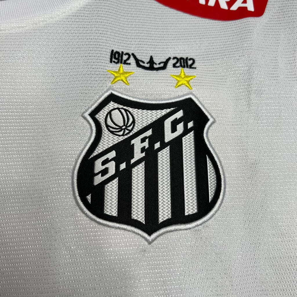 Maillot rétro Santos 2011-12 de la marque Le 12-ème Maillot, maillot de football avec logo et design vintage visible.