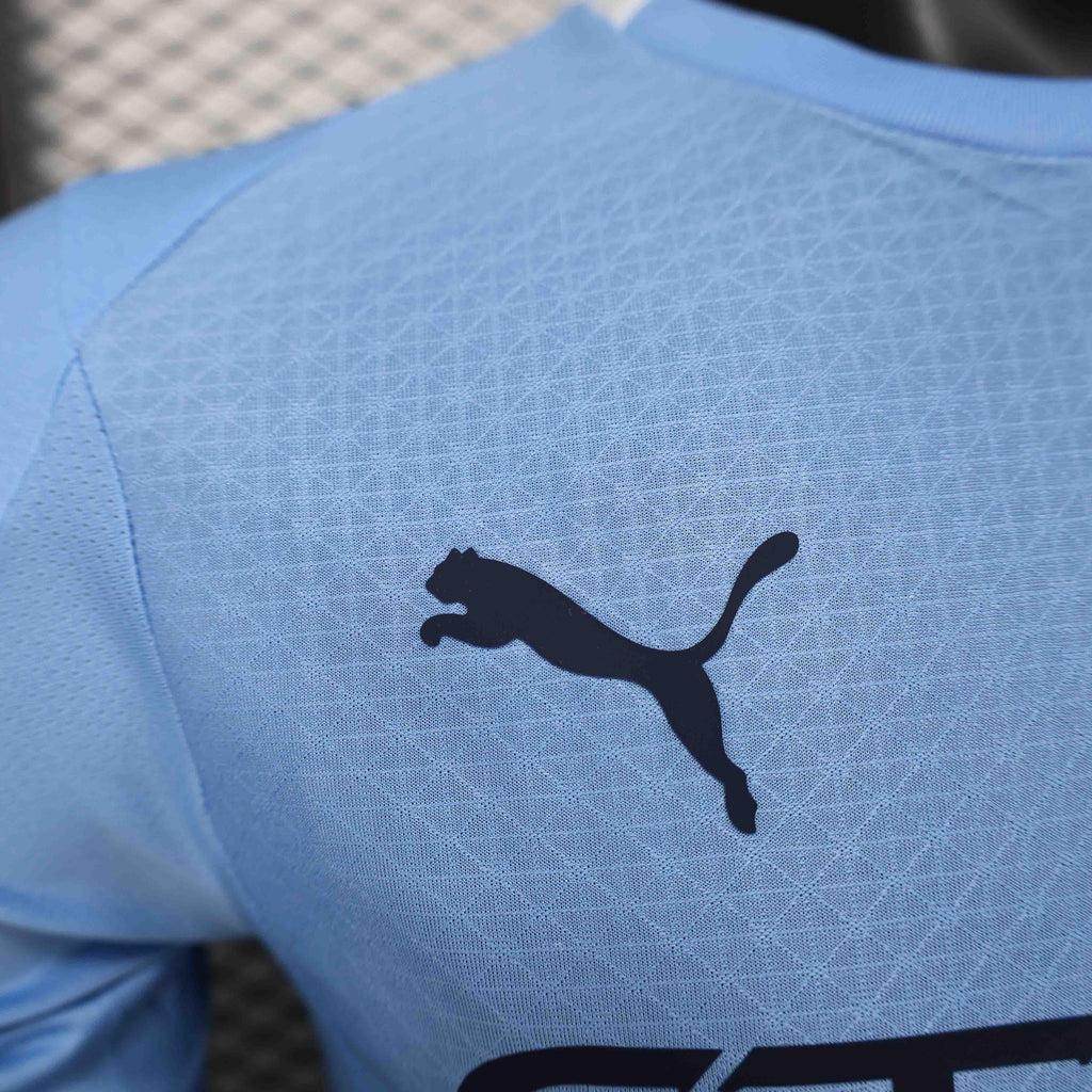 Maillot Manchester City 25-26 ans, marque Le 12 -ème Maillot, porté par un supporter, avec logo et détails de l'équipe.