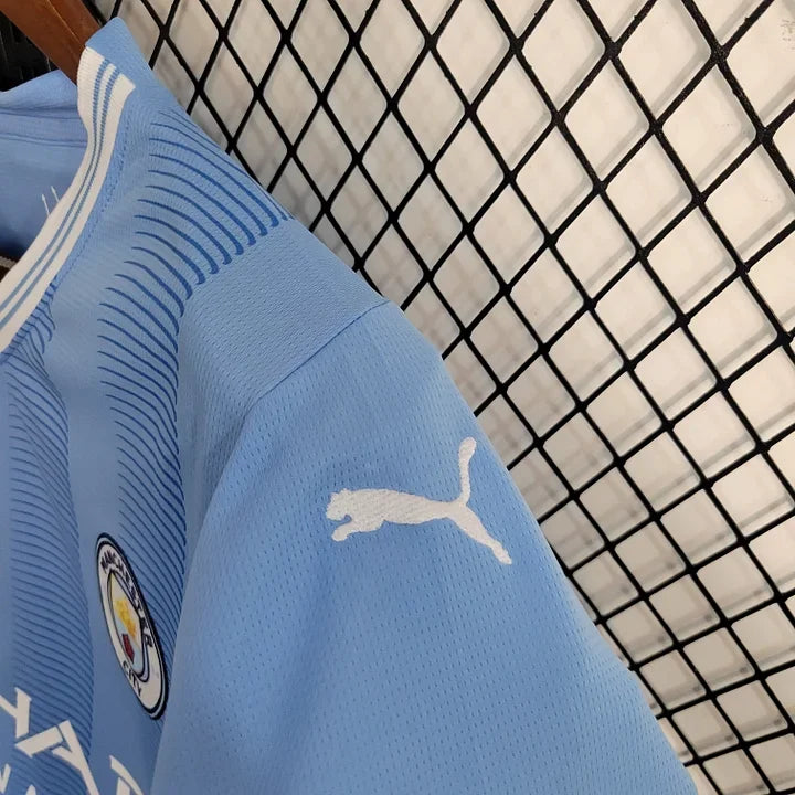 Maillot domicile Manchester City 2023-2024 Le 12 -ème Maillot, maillot de football bleu avec logo et détails officiels.