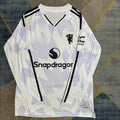 Maillot extérieur Manchester United 25/26 à manches longues, de la marque Le 12-ème Maillot, avec logo et design officiel.