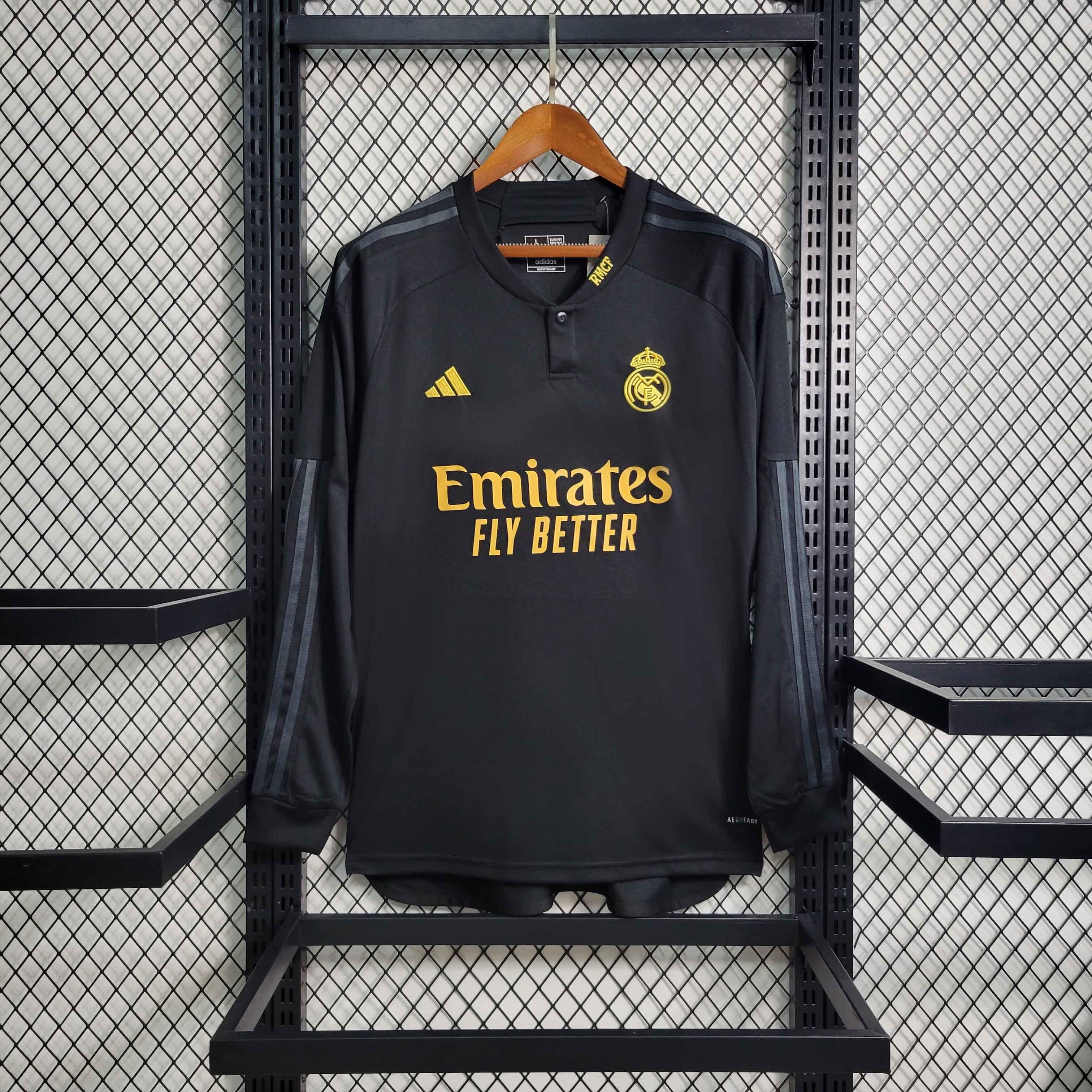 Maillot manches longues Real Madrid 2023-24 Le 12 -ème Maillot, maillot de football blanc avec logo du club et détails bleus.