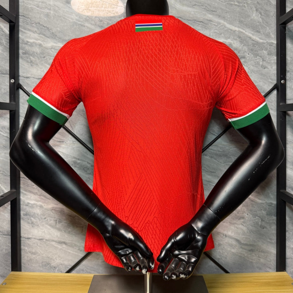 Maillot de football Le 12-Gambia rouge pour enfant taille 25/26, joueur en action sur le terrain.