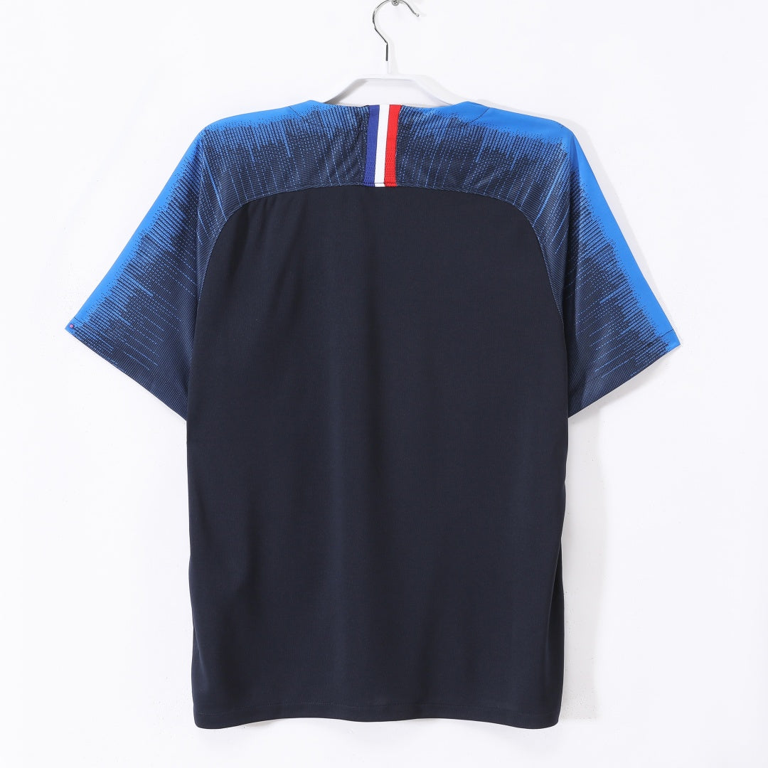Maillot rétro domicile de l'équipe de France 2018, marque Le 12 -ème Maillot, avec les couleurs et le logo nationaux.