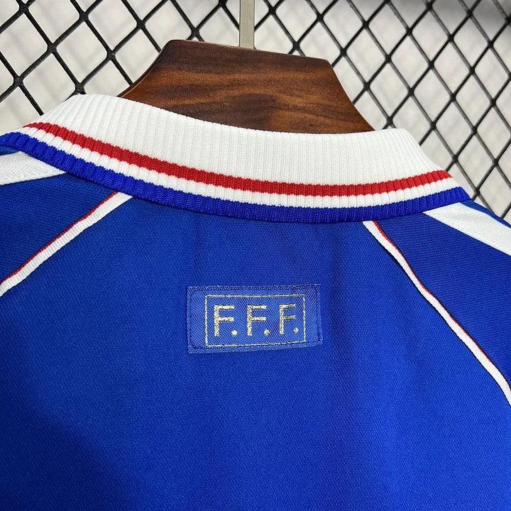 Maillot rétro de l'équipe de France 1998, en tissu bleu avec motifs et logo officiel, de la marque Le 12 -ème Maillot.