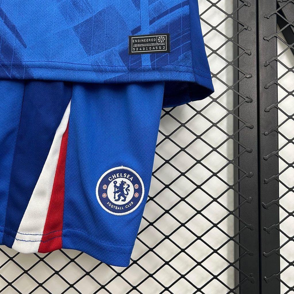 Kit enfant Chelsea 2025-26 de Le 12 -ème Maillot, maillot bleu et blanc avec logo du club, porté par un enfant.