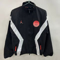 Veste coupe-vent réversible Le 12 -ème Maillot PSG noire, détails du logo et design sportif visible.