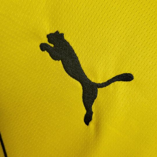 Maillot Dortmund 2023-2024 à manches longues, marque Le 12 -ème Maillot, tissu rouge avec détails noirs et logo du club.