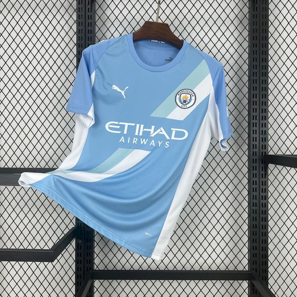 Maillot Manchester City 2025-26 de Le 12 -ème Maillot, vue de face avec logo et détails du maillot bleu et blanc.