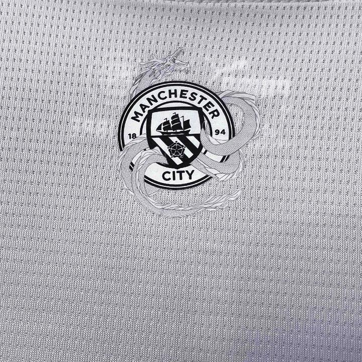 Maillot Manchester City 2023-2024 édition Nouvel An Chinois, Le 12 -ème Maillot, vue front avec logo et détails colorés