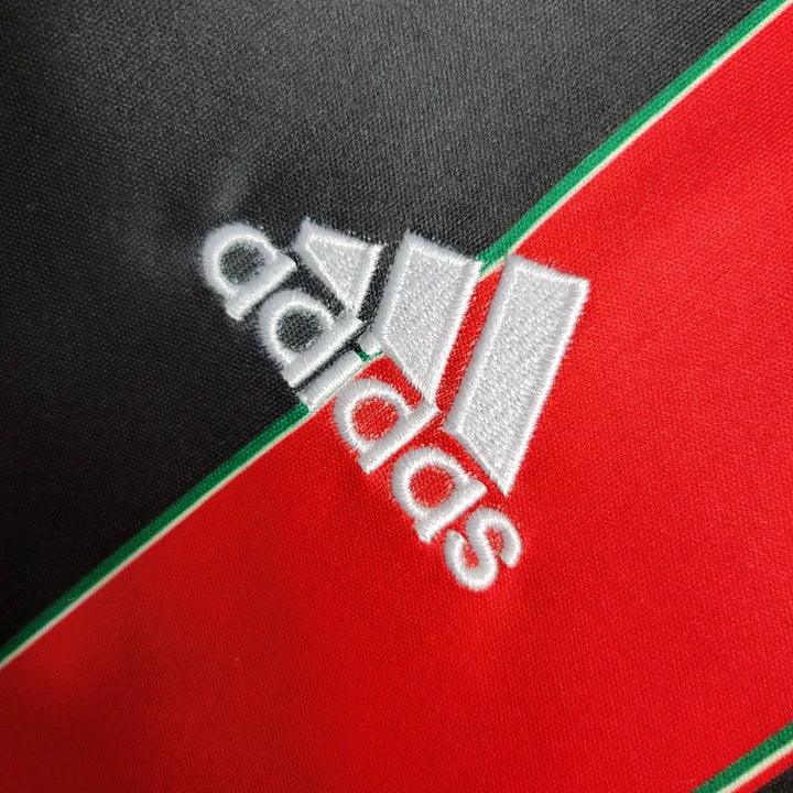 Maillot rétro AC Milan 2012-2013 de la marque Le 12-ème, vue de face avec les couleurs traditionnelles rouge et noir.