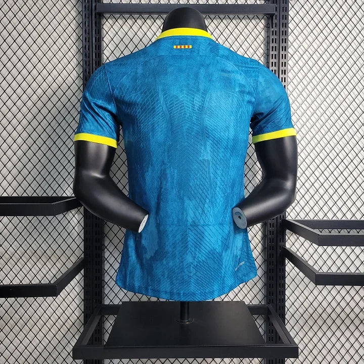 Maillot extérieur FC Barcelone 2023 2024 Le 12, maillot de football bleu avec le logo du club et motifs modernes.