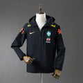 Veste coupe-vent réversible Le 12ème Maillot, style Brésil noir, avec capuche et design léger visible sur l'image.