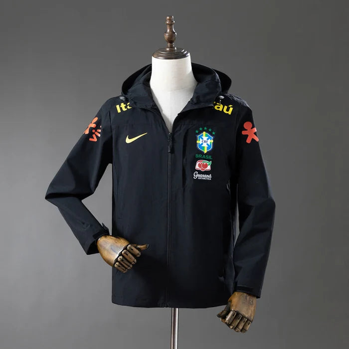 Veste coupe-vent réversible Le 12ème Maillot, style Brésil noir, avec capuche et design léger visible sur l'image.