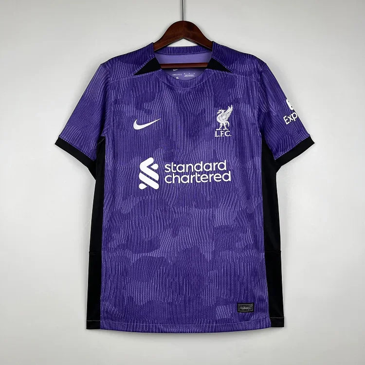 Maillot Liverpool saison 2023-2024 troisième, marque Le 12 -ème Maillot, vue de face avec logo et détails du design orange et noir.