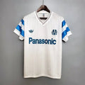 Maillot Marseille Rétro 1990 de la marque Le 12-ème Maillot, vue de face avec logo et design vintage bleu et blanc.