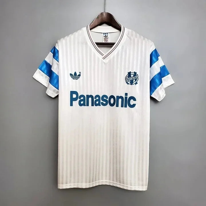 Maillot Marseille Rétro 1990 de la marque Le 12-ème Maillot, vue de face avec logo et design vintage bleu et blanc.
