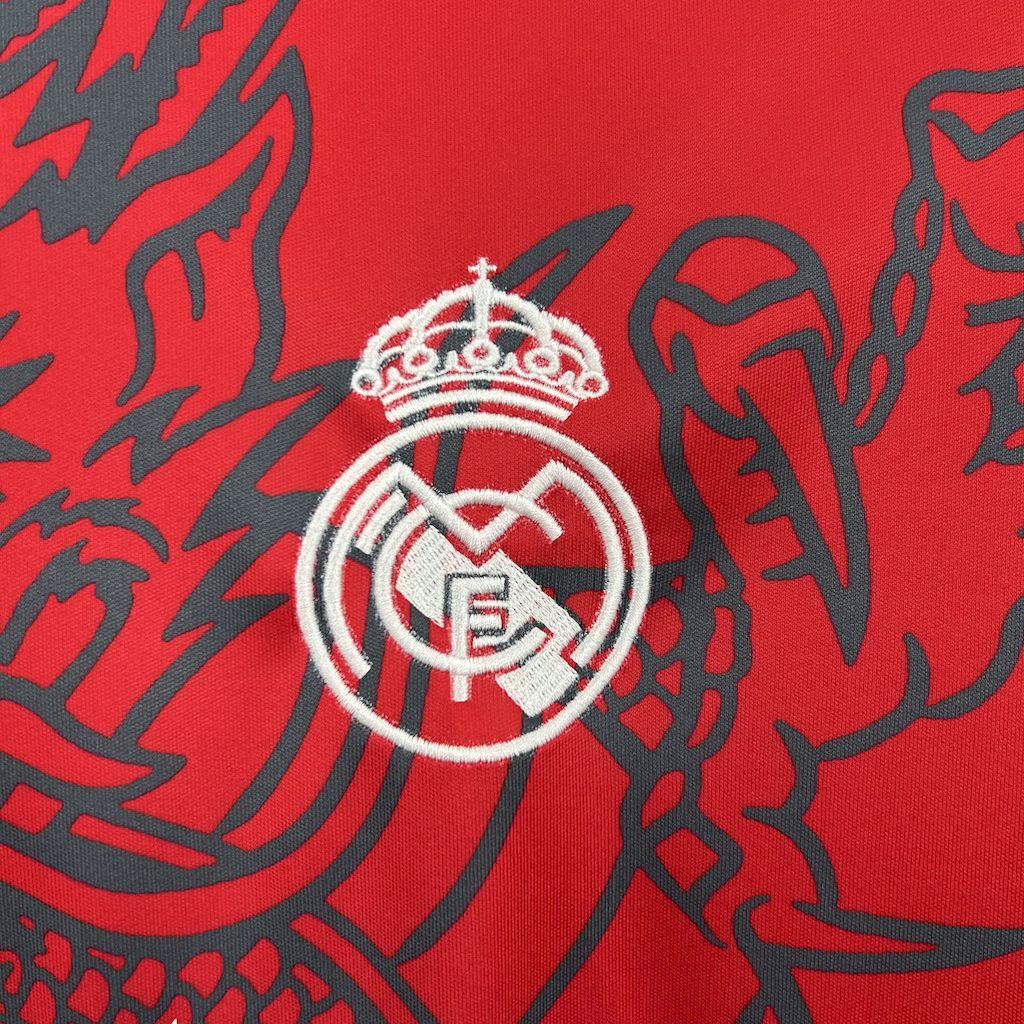 Maillot 24-25 Real Madrid Le 12-ème Maillot, maillot de football blanc avec logo du Real Madrid et détails en bleu.