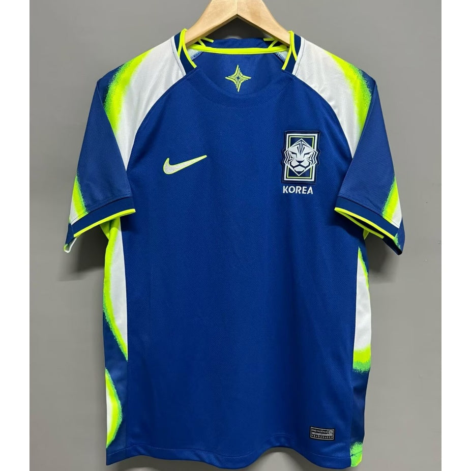 Maillot extérieur de football Corée du Sud Le 12, maillot 25/26, design en bleu avec logos de l'équipe nationale.