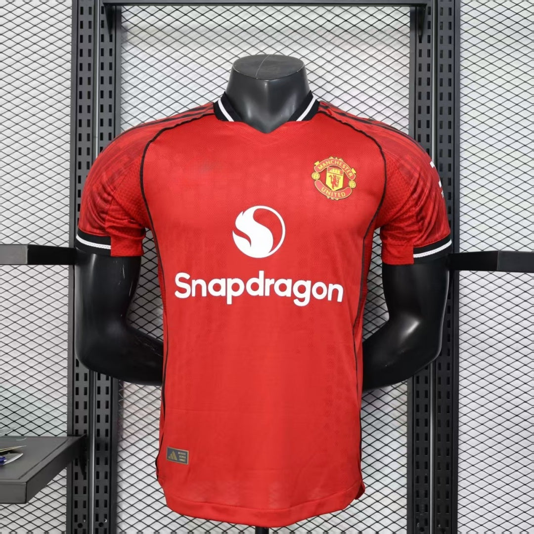 Maillot domicile Manchester United version joueur 25/26, marque Le 12 -ème Maillot, vue de face avec logo et numéros.