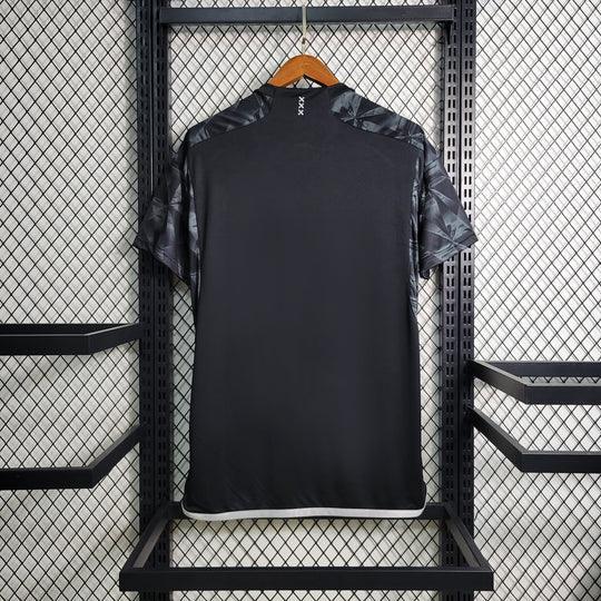 Maillot Ajax 2023-2024 troisième édition noire de Le 12 -ème Maillot, porté avec détails du logo et design sportif.