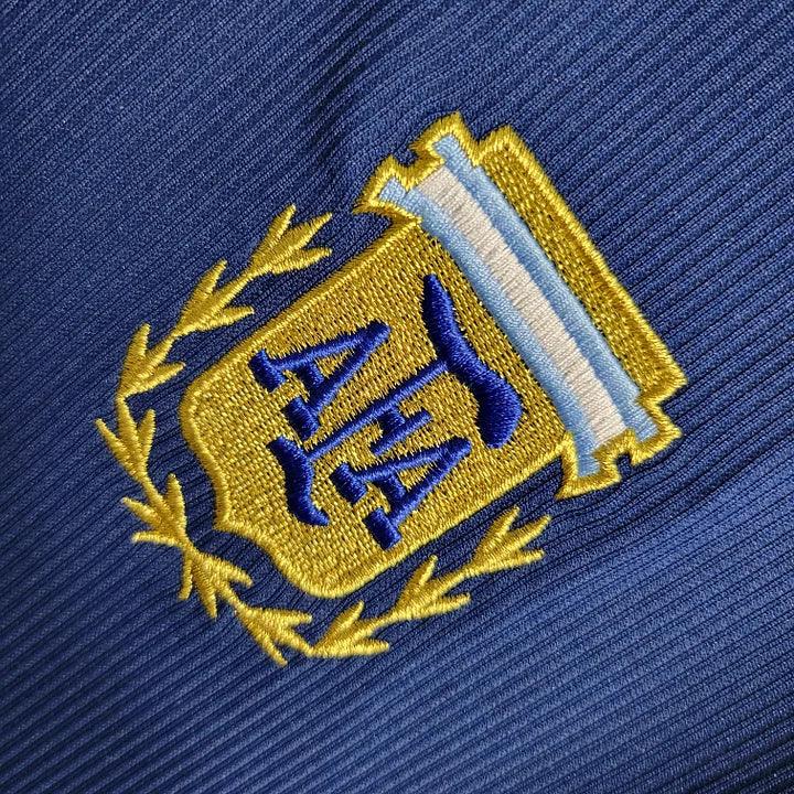 Maillot Argentine rétro 1998 de Le 12 -ème Maillot, maillot de football bleu avec détails argentés et logo national.