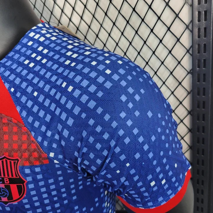 Maillot d'entraînement FC Barcelone 2023-2024 Le 12-ème Maillot, logo du club visible, tissu respirant bleu et grenat.