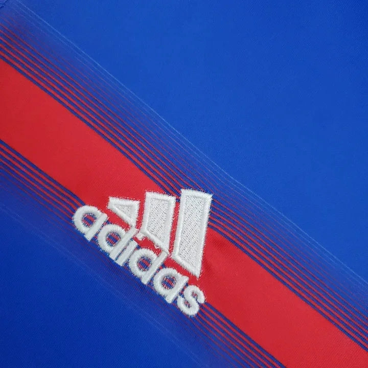 Maillot de l'équipe de France 2004, made by Le 12, affichant les couleurs traditionnelles bleu, blanc et rouge.