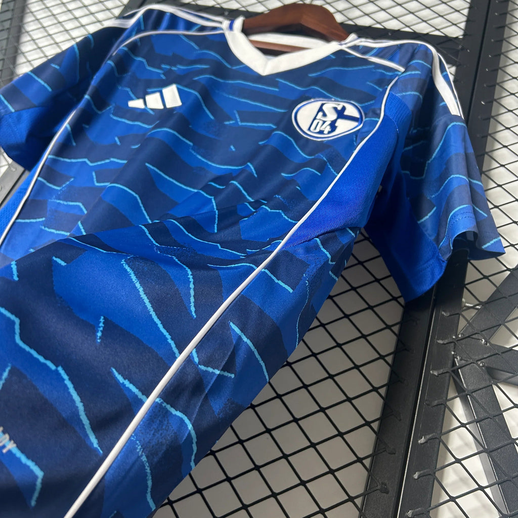 Écharpe officielle du club Schalke 04 à domicile 25/26, avec logo et couleurs bleues et blanches, portée en extérieur.