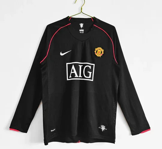Maillot extérieur Manchester United 07-08 à manches longues, marque Le 12 -ème Maillot, en tissu rouge avec logo et détails blancs.