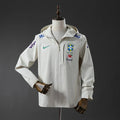 Veste coupe-vent réversible Le 12 ème Maillot, motif Brésil blanc, avec capuche et poches, vue de face sur fond blanc.