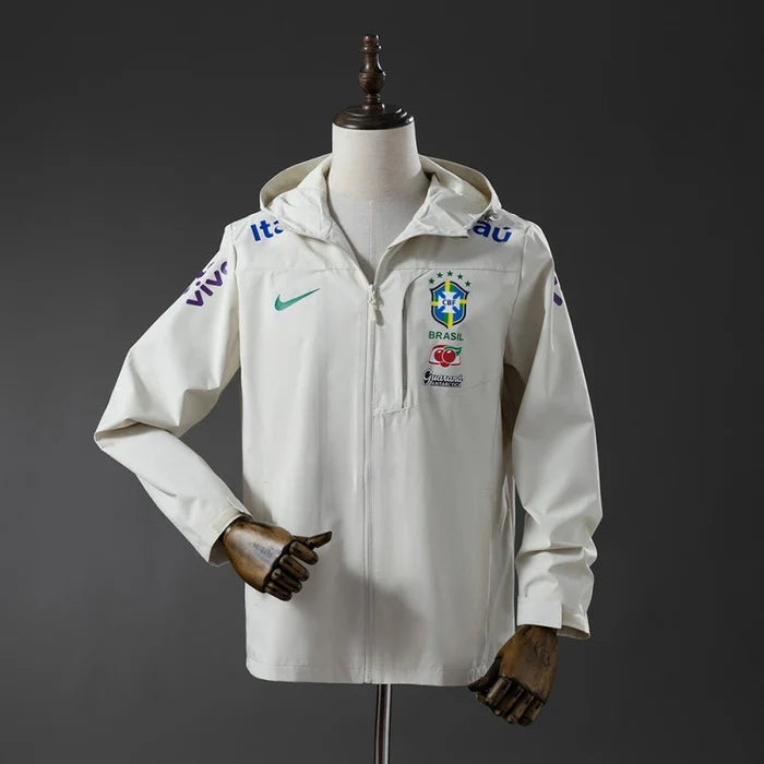 Veste coupe-vent réversible Le 12 ème Maillot, motif Brésil blanc, avec capuche et poches, vue de face sur fond blanc.