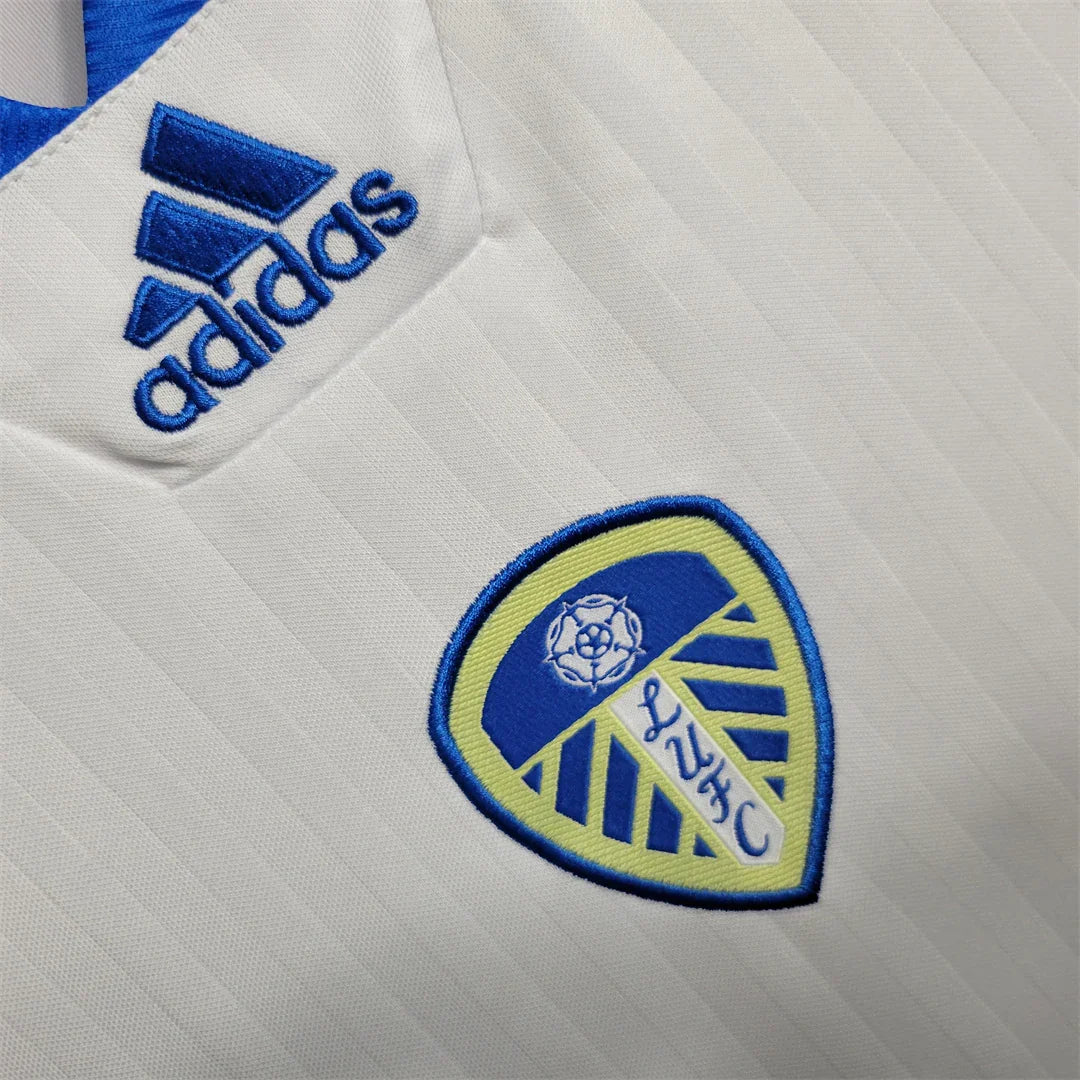Maillot Leeds United 2024-25 Le 12 -ème Maillot, maillot de football blanc avec logo et détails verts et bleus, vue de face