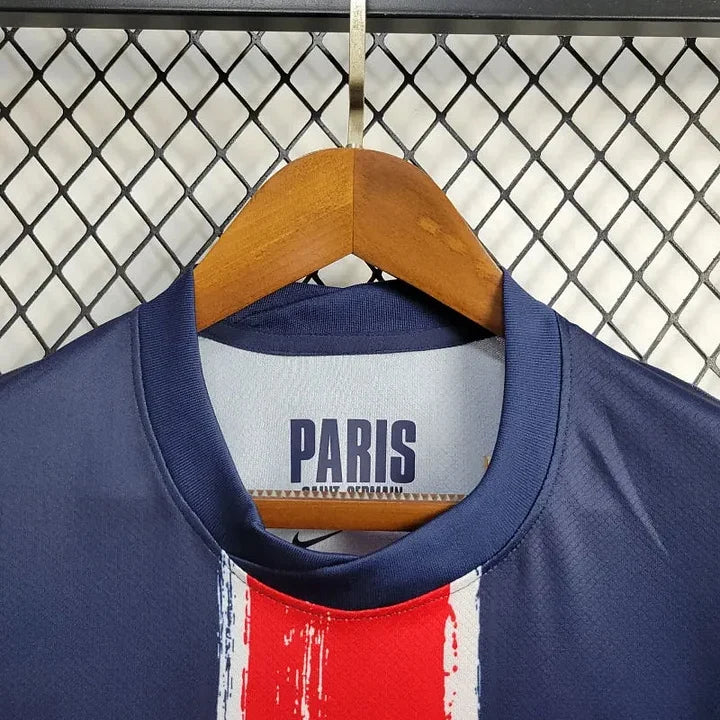 Maillot Paris Saint Germain 2024/25 Le 12 -ème Maillot, maillot de football blanc avec logo du PSG et détails bleus.