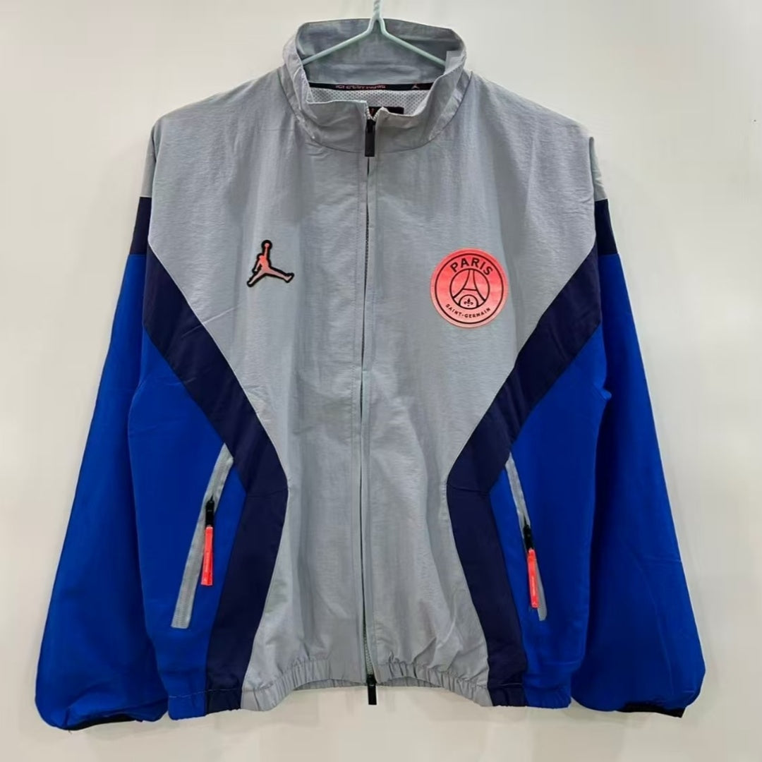 Veste coupe-vent réversible PSG gris de la marque Le 12-ème Maillot, vue de face avec logo Paris Saint-Germain visible.