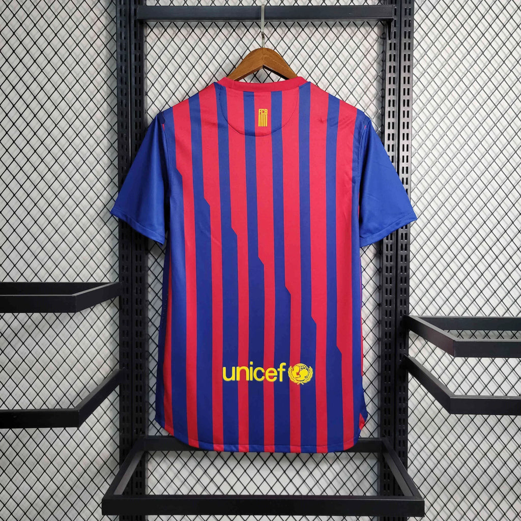Maillot 11/12 Barcelone rétro de Le 12 -ème Maillot, maillot de football bleu avec le logo du club et numéros blancs.