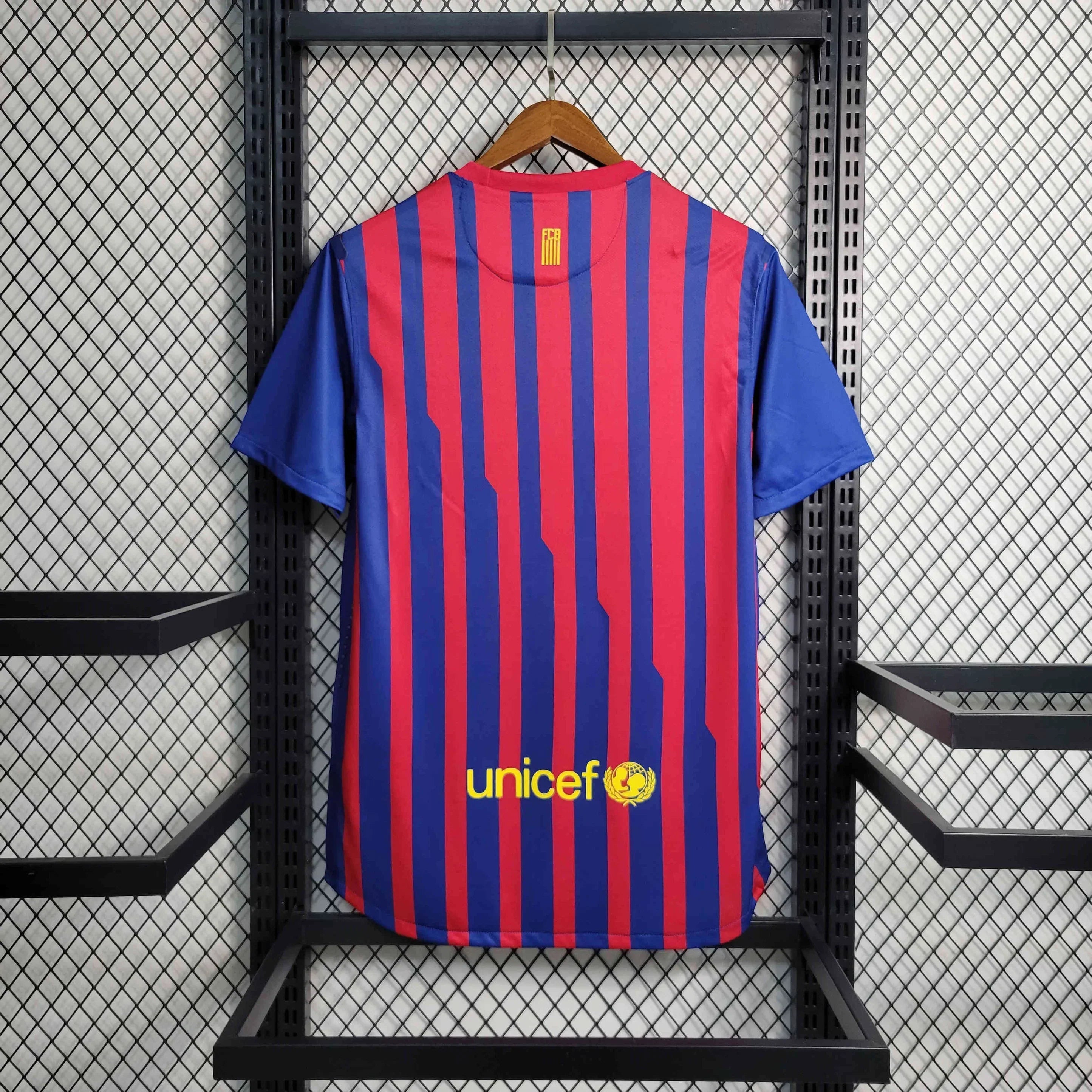 Maillot 11/12 Barcelone rétro de Le 12 -ème Maillot, maillot de football bleu avec le logo du club et numéros blancs.