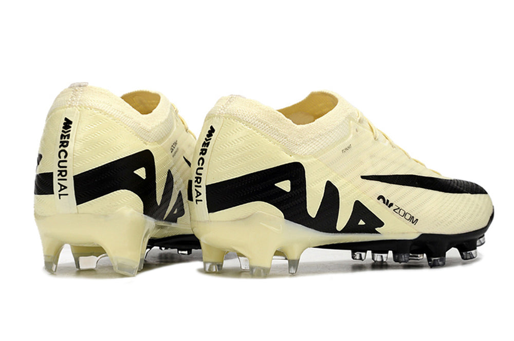 Crampons Mercurial Vapor 15 Elite XXV de Le 12 -ème Maillot, vue en gros plan avec pointes en métal et design noir et orange