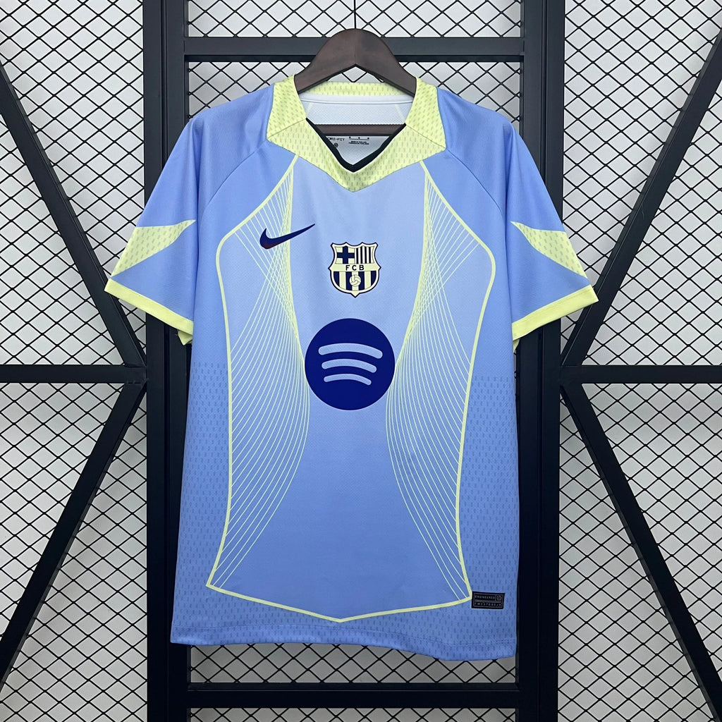 Maillot de football FC Barcelone 25/26 bleu ciel, marque Le 12 -ème Maillot, vue en gros plan sur le tissu et le logo.