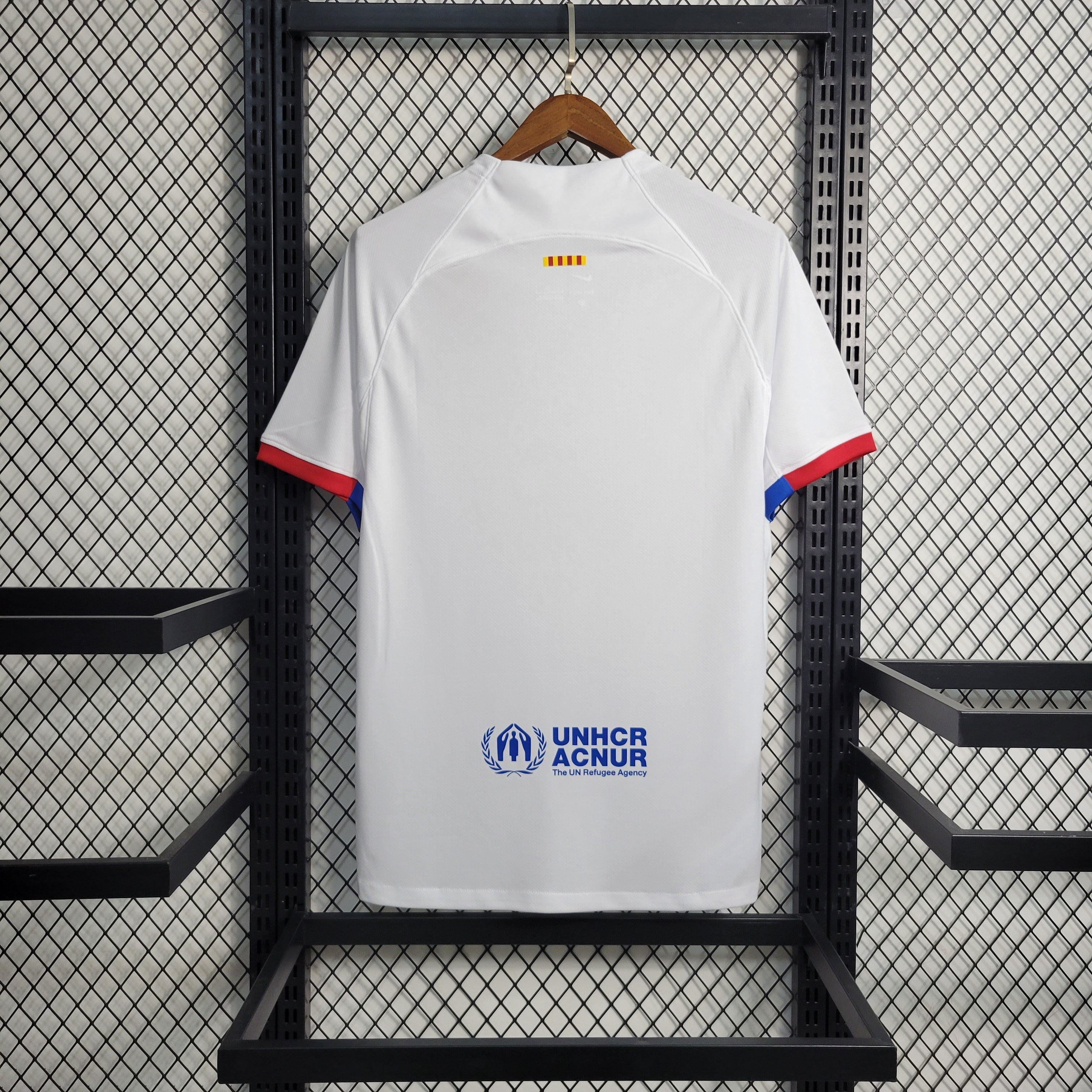 Maillot extérieur du FC Barcelone 2023-2024, marque Le 12, avec le logo du club et design bleu et grenat visible sur le maillot.