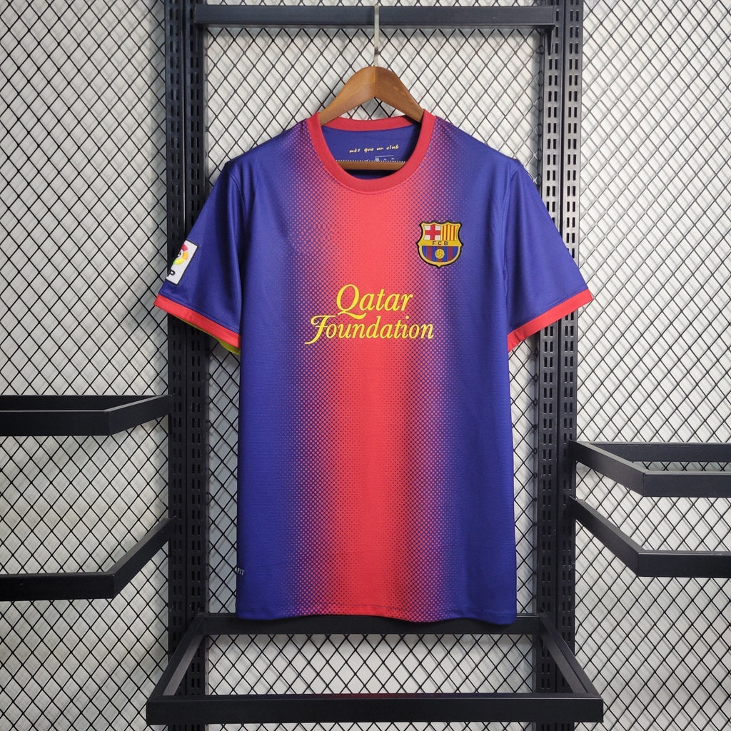 Maillot rétro FC Barcelone 2012-2013 Le 12ème Maillot, maillot de football avec logo et design vintage sur le terrain.