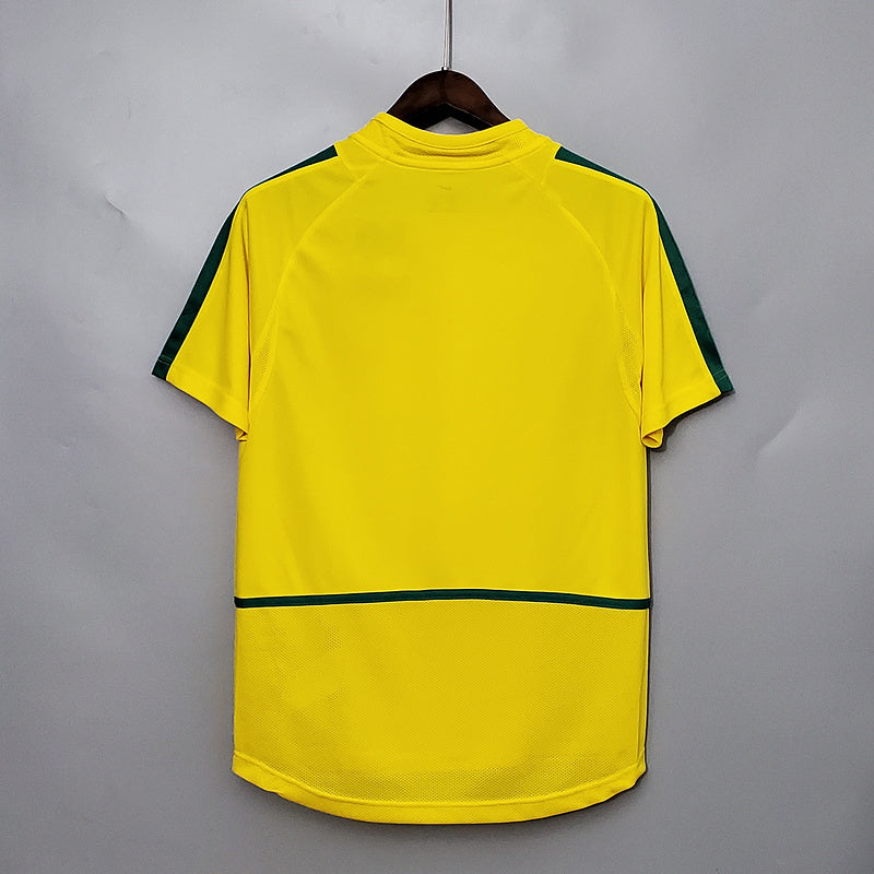 Maillot domicile rétro du Brésil 2002, marque Le 12 -ème Maillot, vue de face avec motifs traditionnels brésiliens.