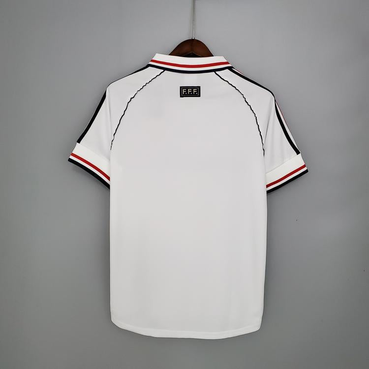 Maillot rétro de l'équipe de France 1998, marque Le 12 -ème Maillot, affichant les couleurs et le design vintage du maillot.