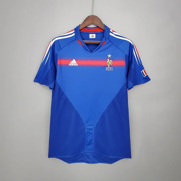 Maillot de l'équipe de France 2004 Le 12, maillot de football bleu avec logo et détails sportifs visibles.